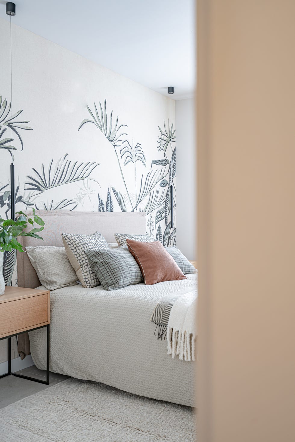 dormitorio con mural de dibujos botánicos en la pared del cabecero