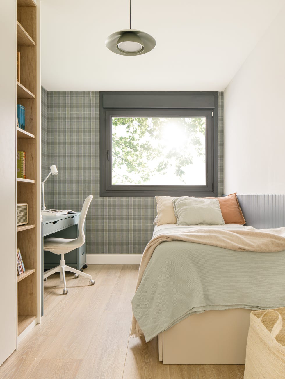 habitación juvenil con escritorio y papel pintado con motivos de cuadros