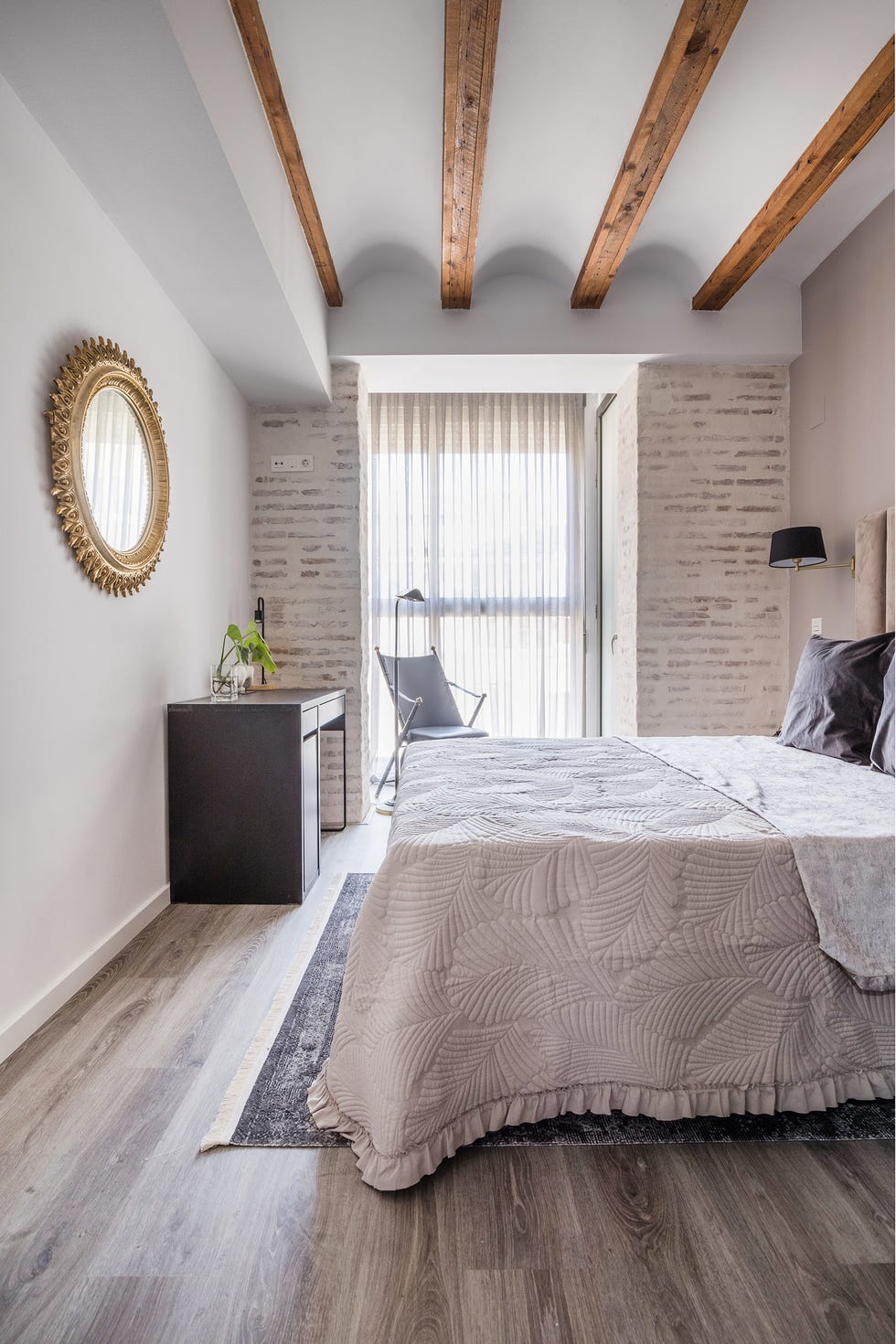 dormitorio con vigas y paredes de ladrillo vistas