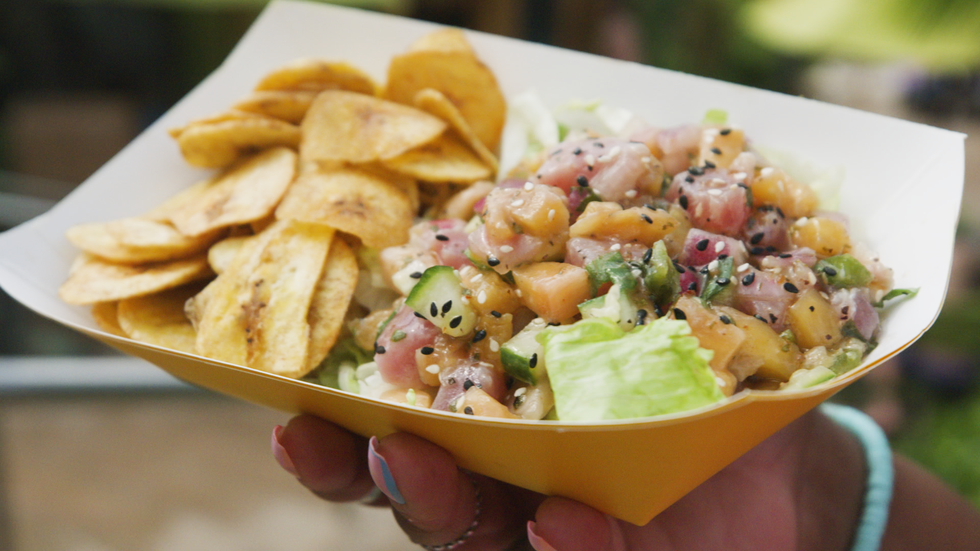 a hand holding a bowl of food
