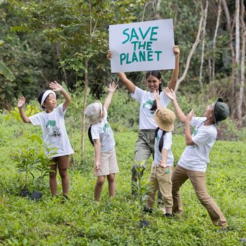 volunteer asian and children holding a sign with the message save the planet