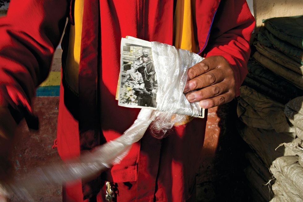 In het dorp van Tong Dui houdt een monnik een foto vast die de auteur zou verbazen