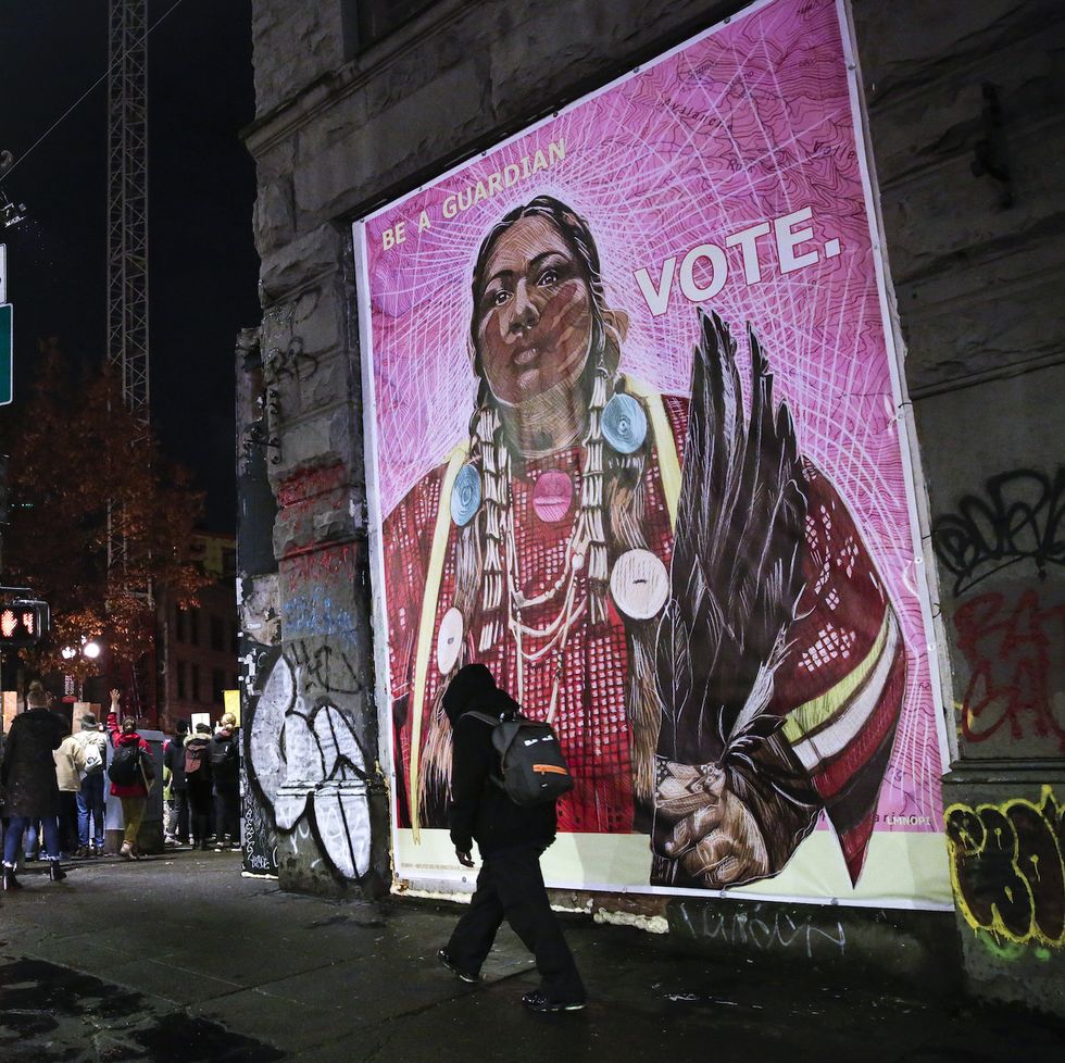 protestors walk past an image of a native american woman during a march to "count every vote, protect every person" on the day after the us presidential election in seattle, washington on november 4, 2020   democratic presidential challenger joe biden on november 4 neared the magic number of 270 electoral votes needed to win the white house with several battleground states still in play, as incumbent president donald trump challenged the vote count photo by jason redmond  afp photo by jason redmondafp via getty images