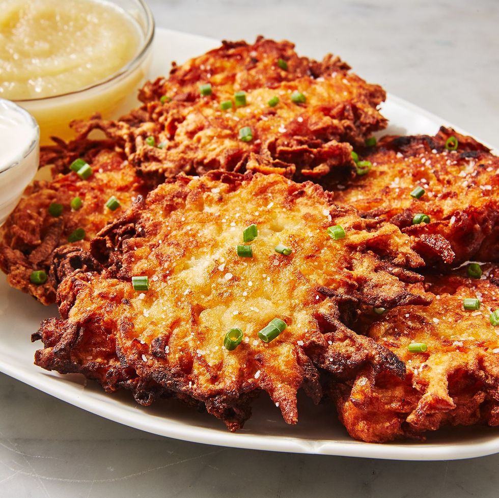 classic potato latkes topped with chives and served with applesauce and sour cream