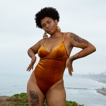 vrouw in een oranje corrigerend badpak aan de kust