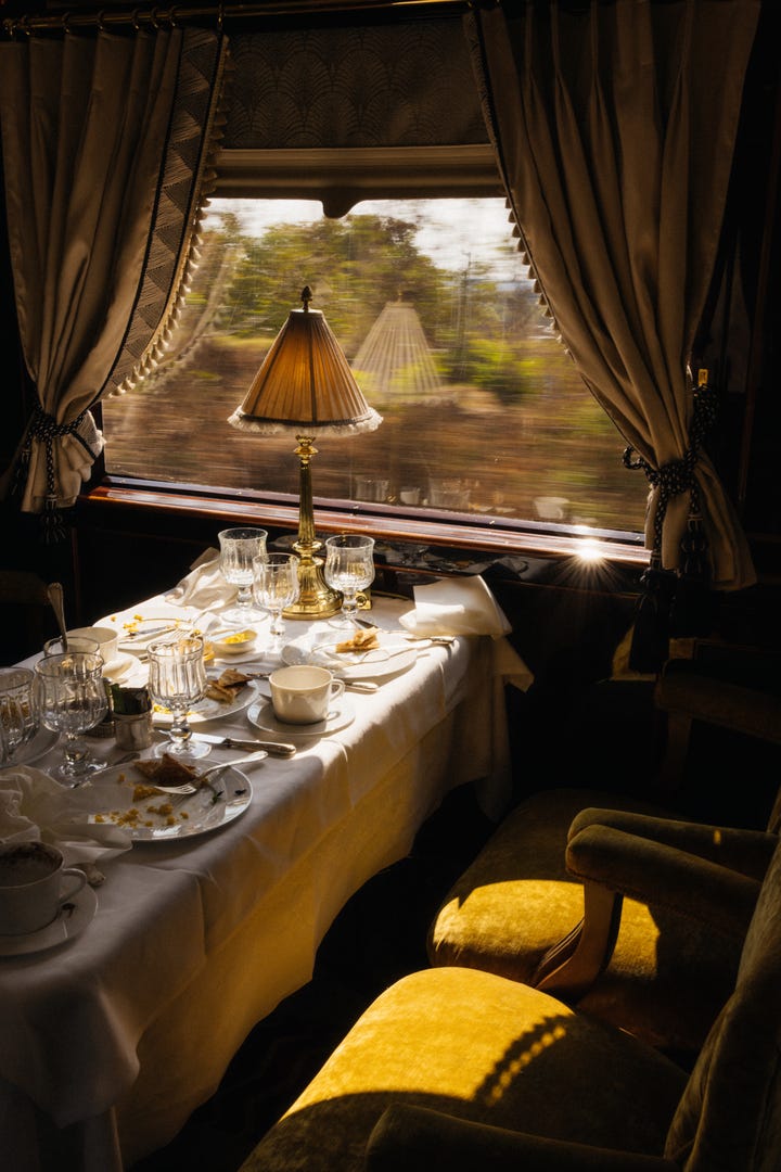 elegant dining setup in a train compartment with scenic view outside