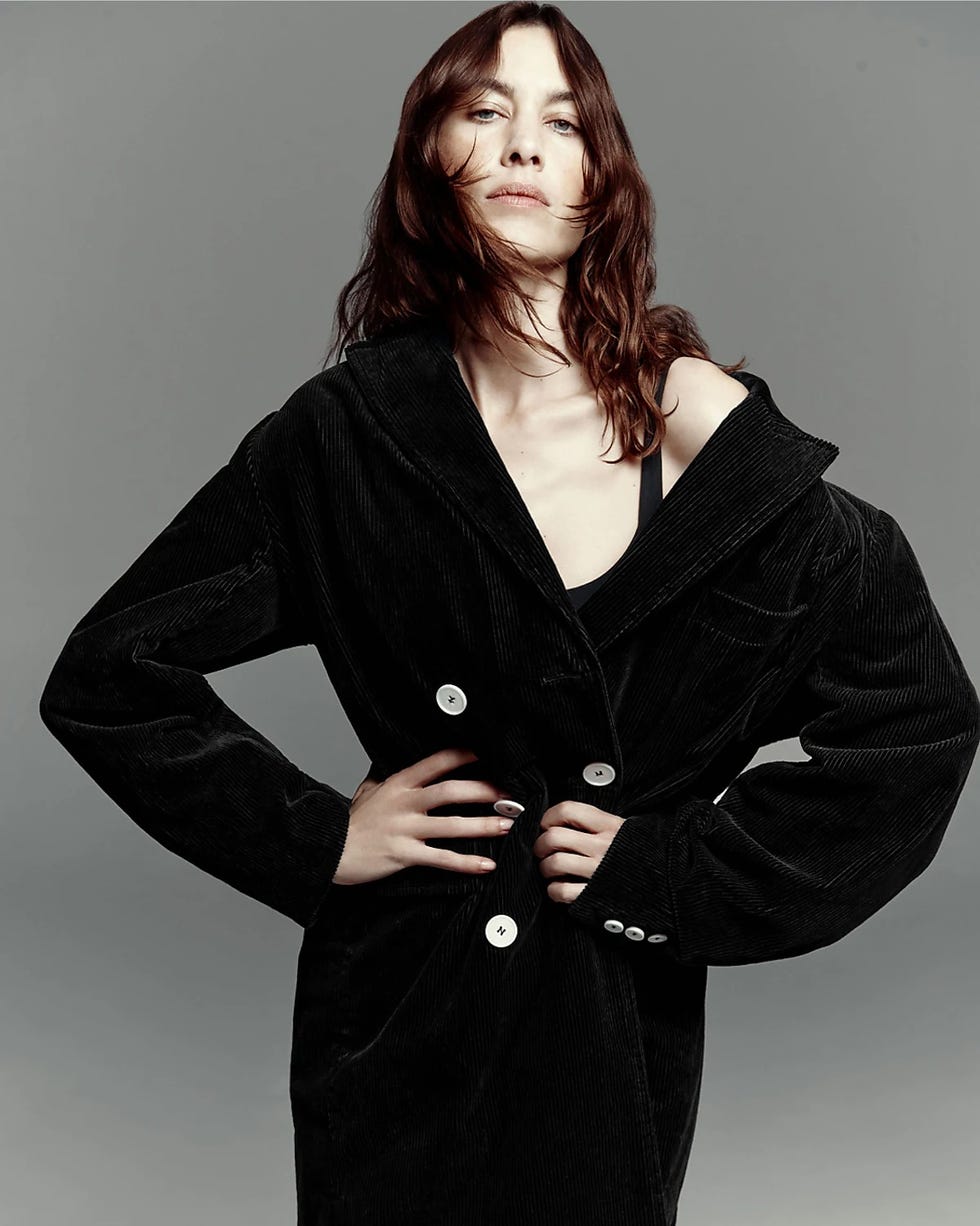 alexa chung wearing a black corduroy oversized coat with a deep collar and decorative buttons