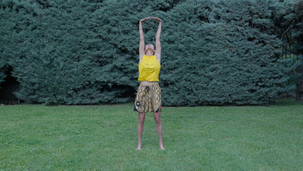 a person standing on the hands in the air in a grassy field