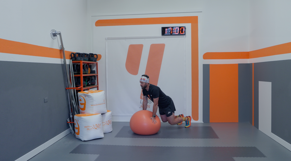 a person kneeling on the floor next to a basketball