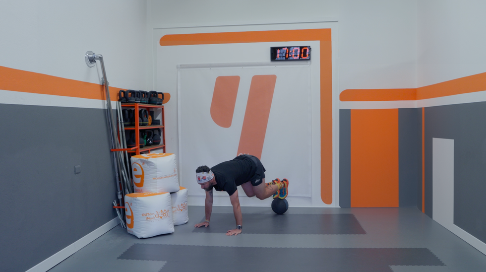 a person bending over to pick up a basketball