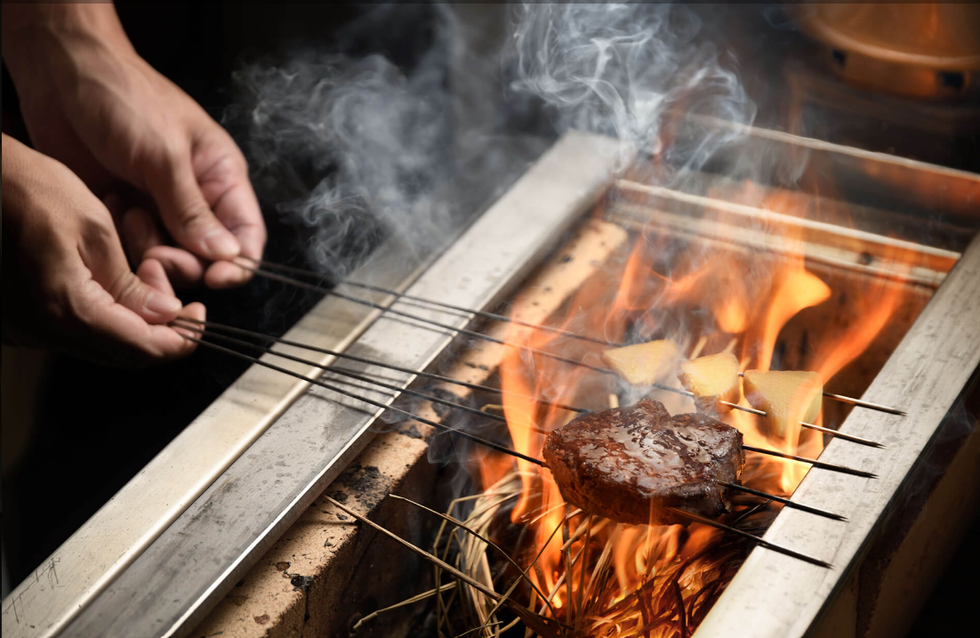 a person putting a fire in a grill