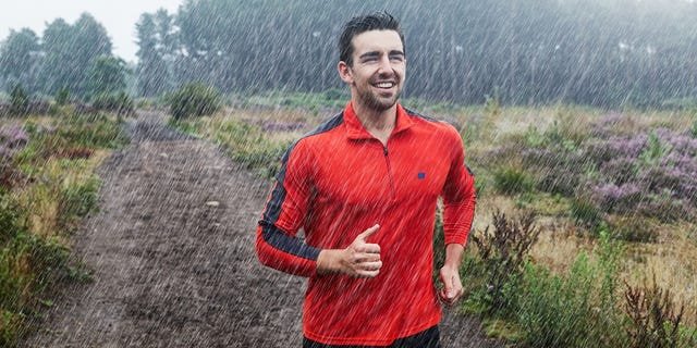 Jogger running on path in rain.