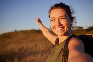 vrouw doet aan wandelen en is zichtbaar gelukkig