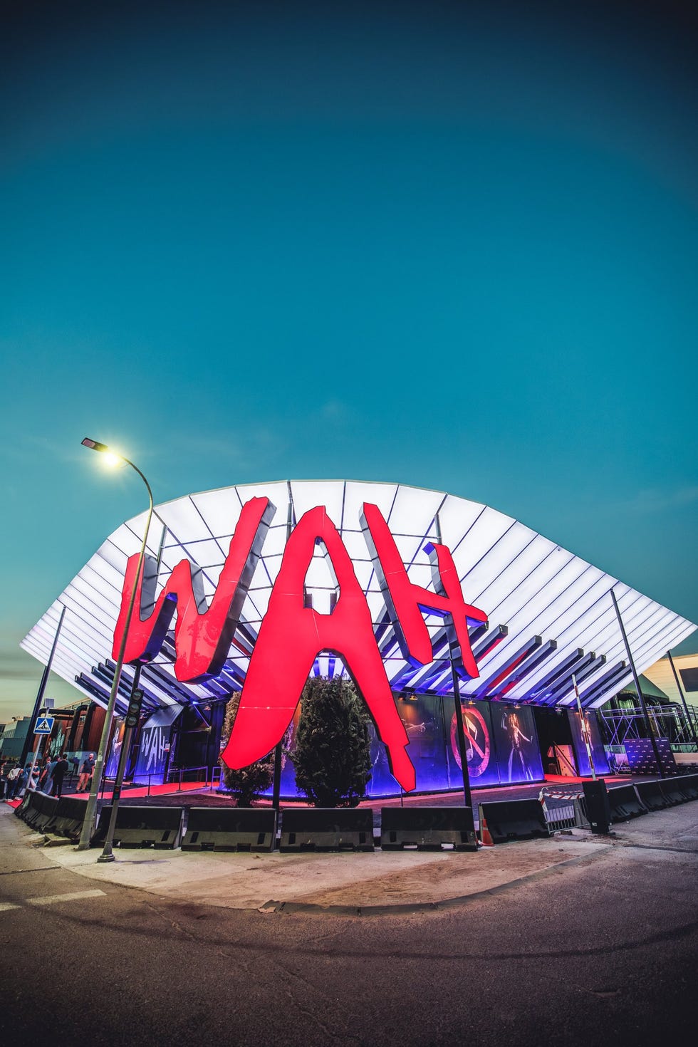 venue with large red signage and illuminated structure against an evening sky