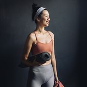 ready for yoga waist up portrait of a  happy asian woman in sports clothes holding an exercise mat