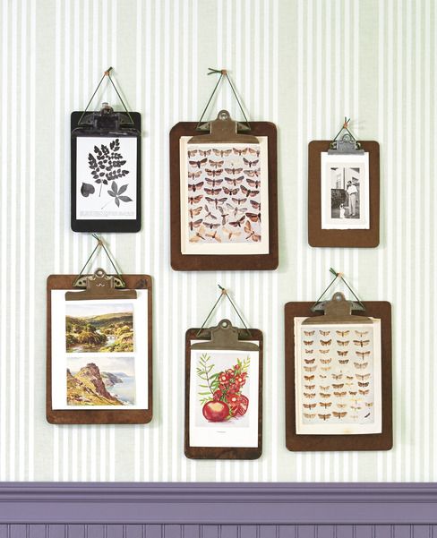 six different sized clipboards hang on  a wall with art clipped to them