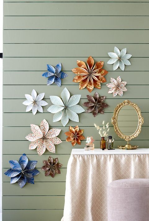 flowers made of colorful wallpaper hang on a wall above a vanity