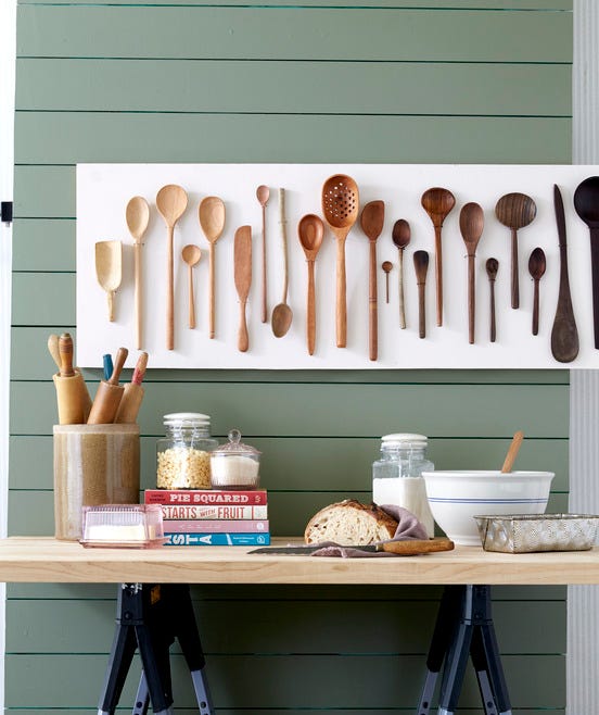 wooden spoons from light to dark hung on a kitchen wall