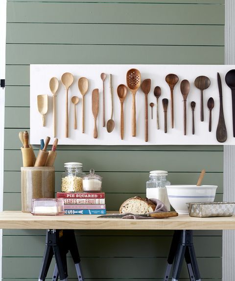 wooden spoons from light to dark hung on a kitchen wall