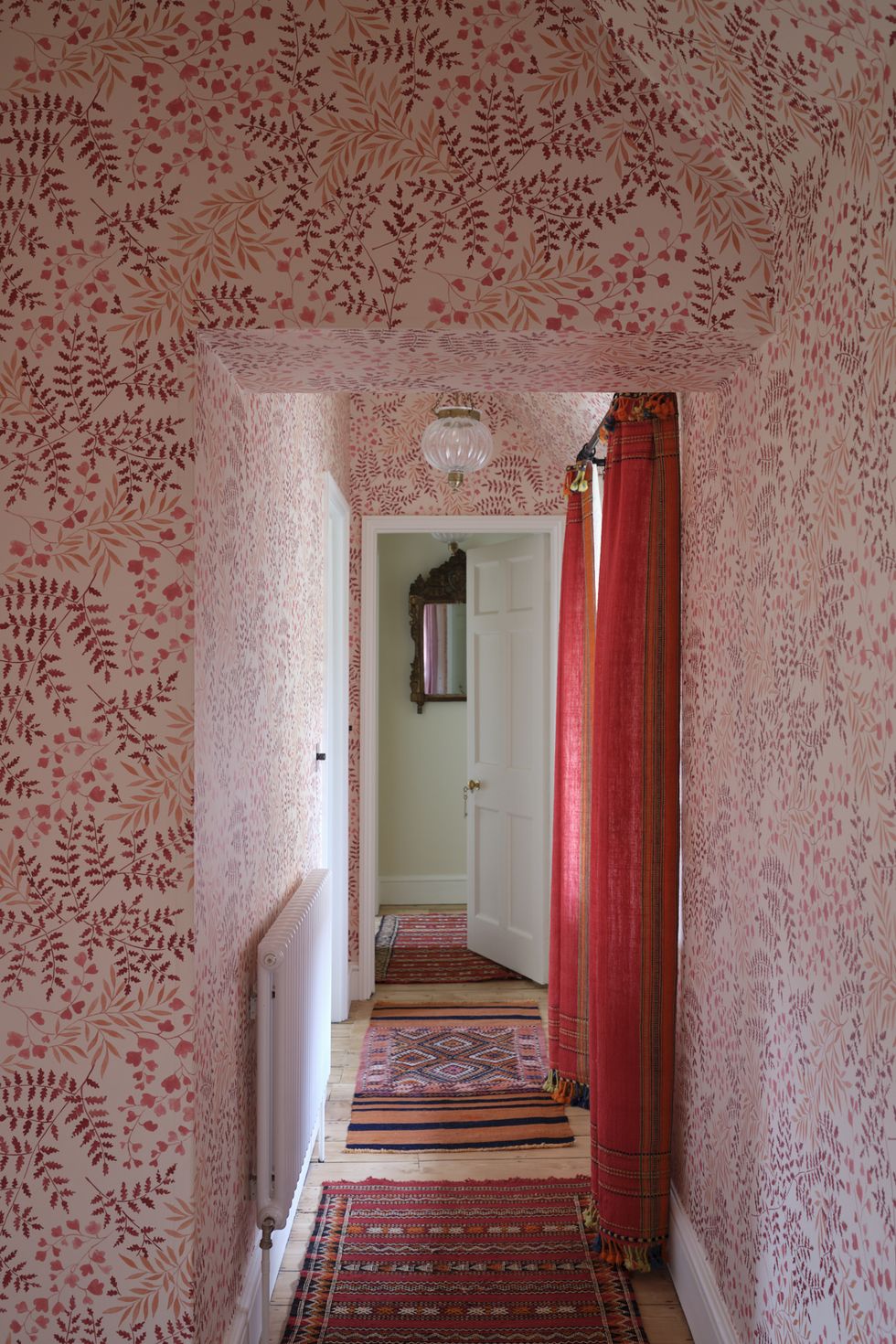 Corridor with red plant wallpaper and red curtains