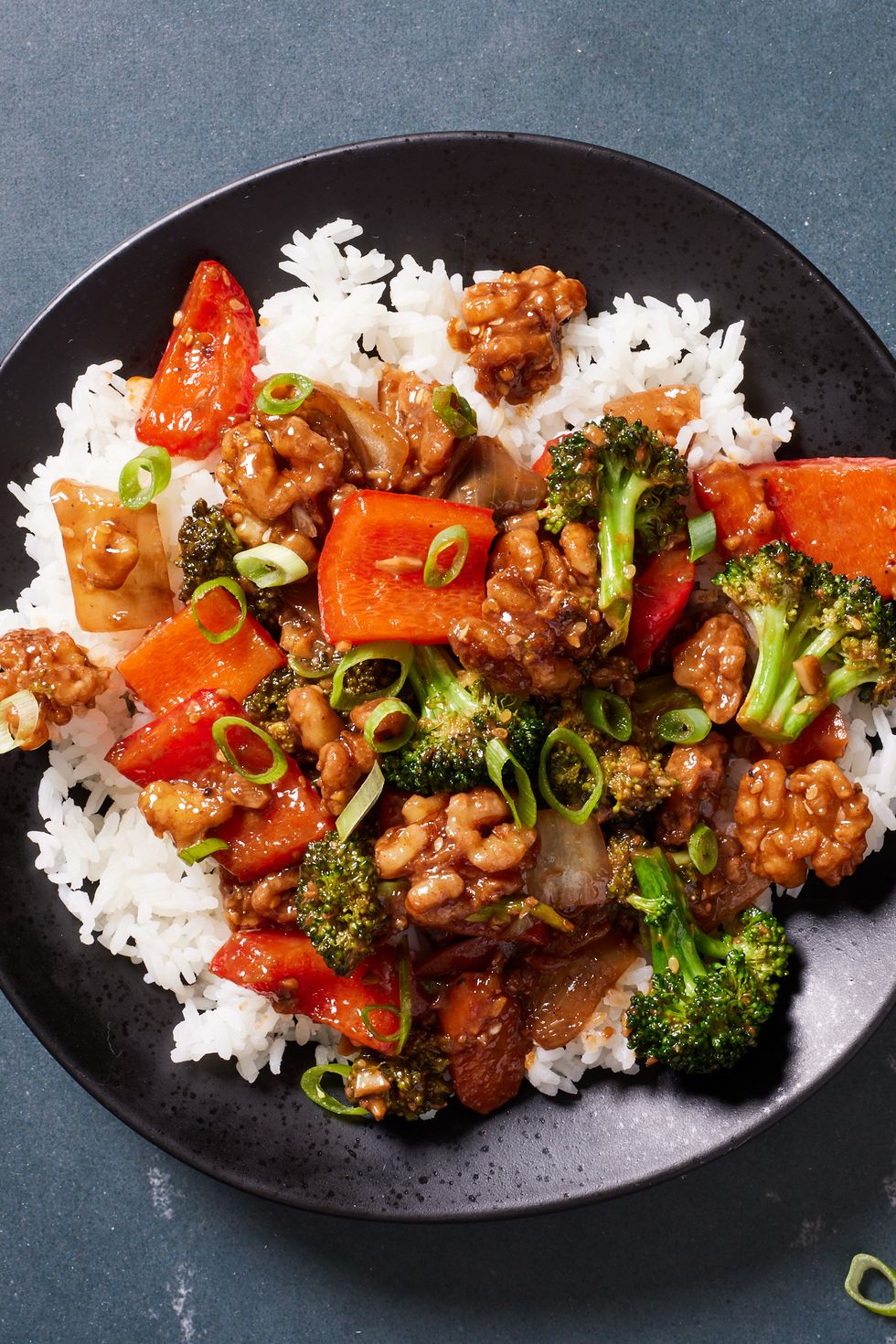 walnut broccoli stirfry on white rice with red bell peppers and glazy sauce