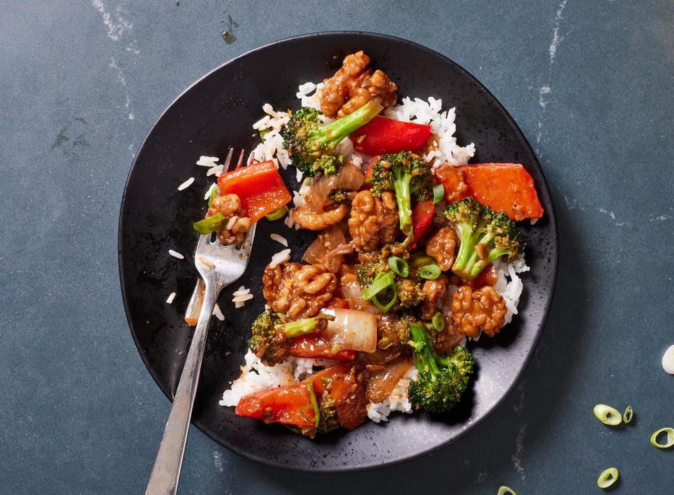 walnut broccoli stirfry on white rice with red bell peppers and glazy sauce