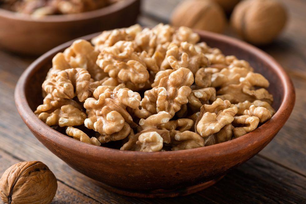 walnuts in brown bowl on wooden table