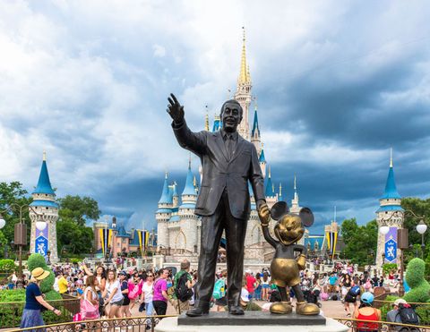 walt disney and mickey mouse statue inside of the magic kingdom