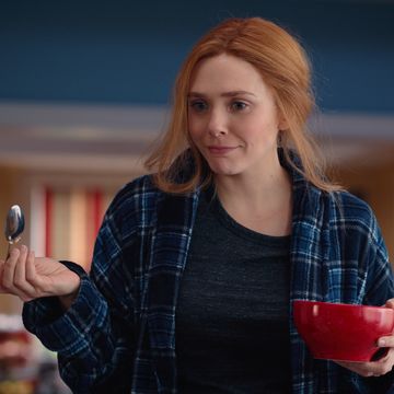 elizabeth olsen as wanda holding a cereal bowl and a spoon in wandavision episode 7 still