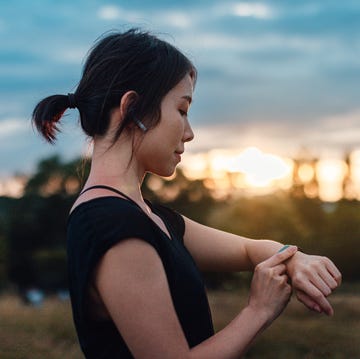 een sportende vrouw neemt even een pauze door op haar sporthorloge te kijken