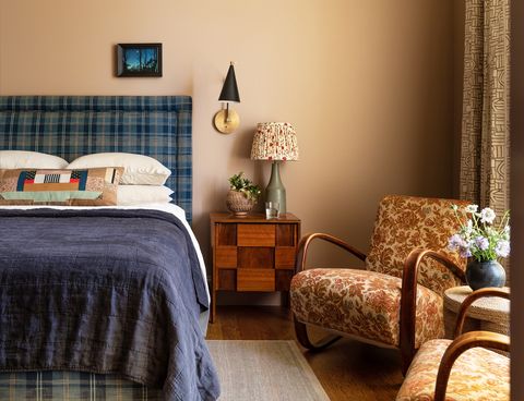 bedroom with blue plaid bedding and warm painted walls