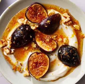 greek yogurt on a plate topped with honey, sliced figs and nuts