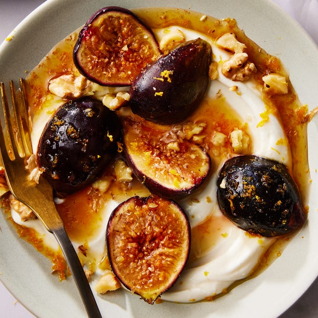 Warm Figs With Honey & Greek Yogurt greek yogurt on a plate topped with honey, sliced figs and nuts