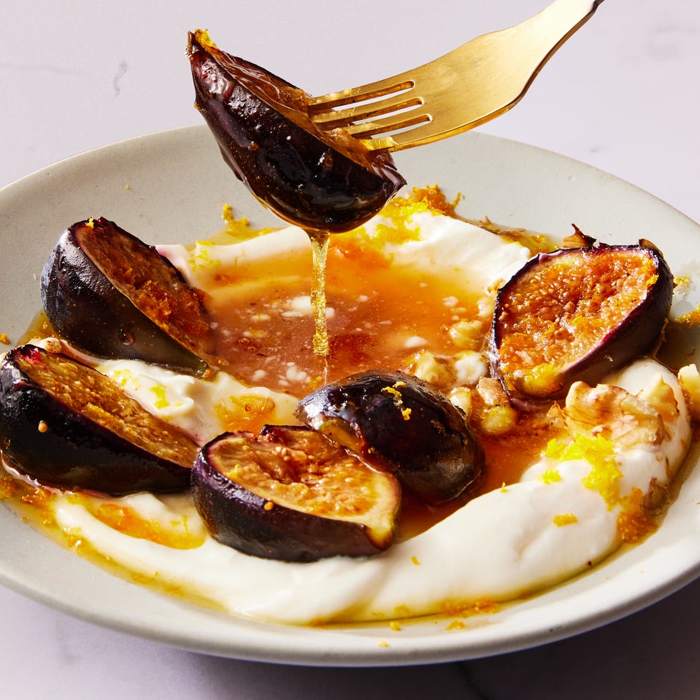 greek yogurt on a plate topped with honey, sliced figs and nuts