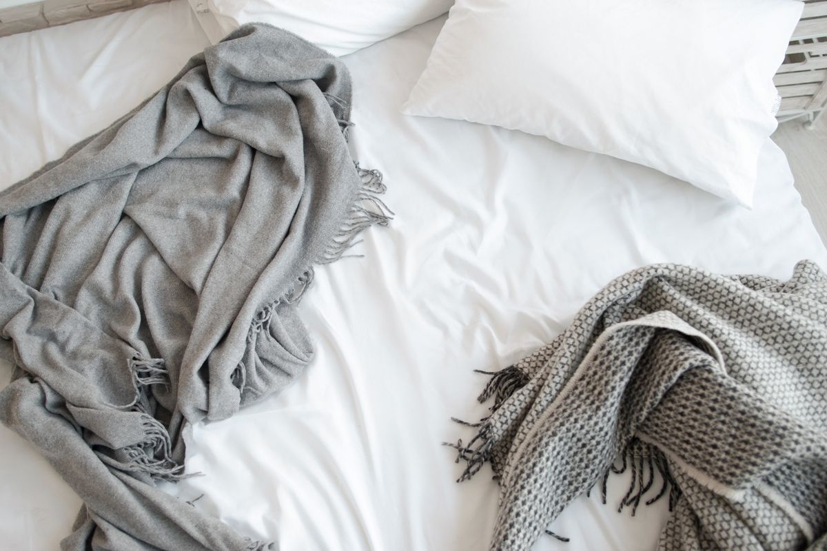 white sheets with grey throw blankets on bed