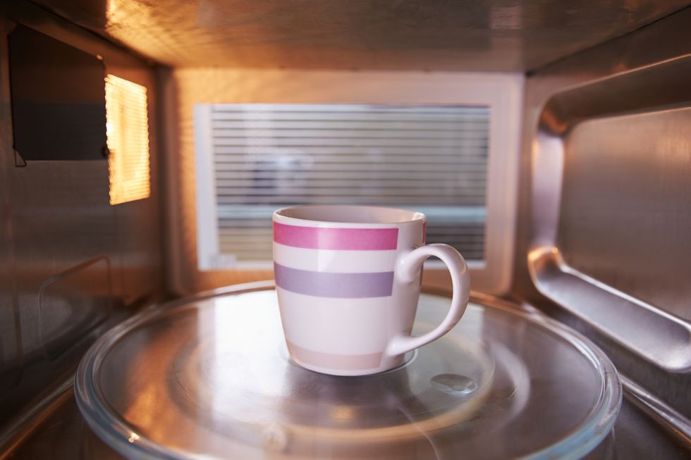 Warming Cup Of Coffee Inside Microwave Oven