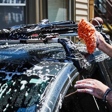 a person spraying water on a car