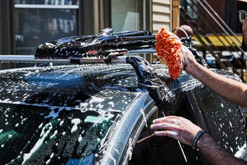 a person spraying water on a car