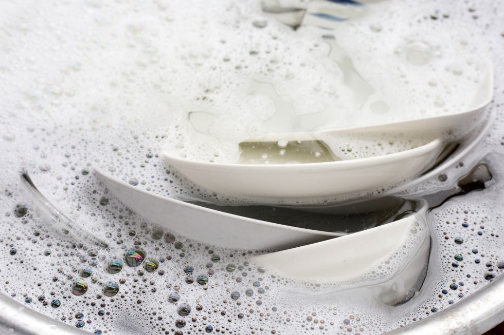 washing dishes, close up of utensils soaking in kitchen sink