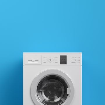 Washing machine at blue wall, frontal view with copy space,3d rendering (general design and captions)