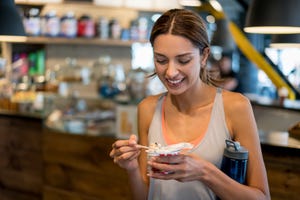 een vrouw eet een snack na het sporten