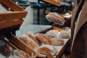 een vrouw houdt een brood vast in de supermarkt