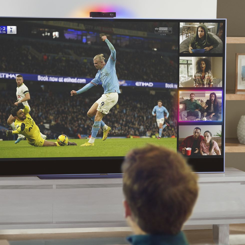 two children watching football on a sky glass tv
