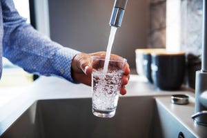 een man haalt water uit de kraan