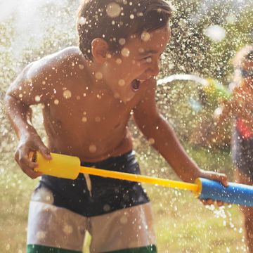 kids playing with water guns in yard