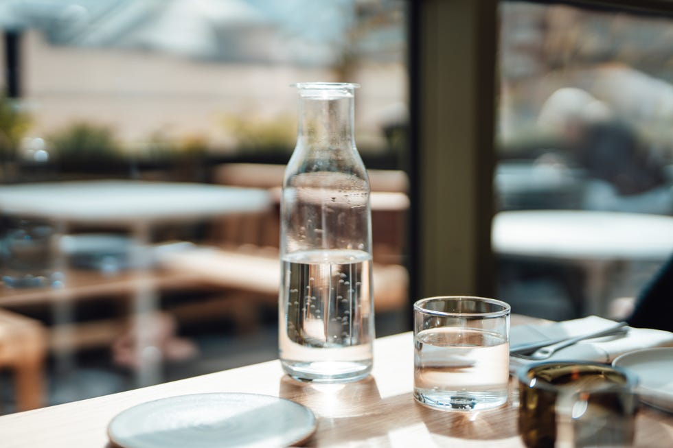 water jug and drinking glass on the wooden table in a restaurant