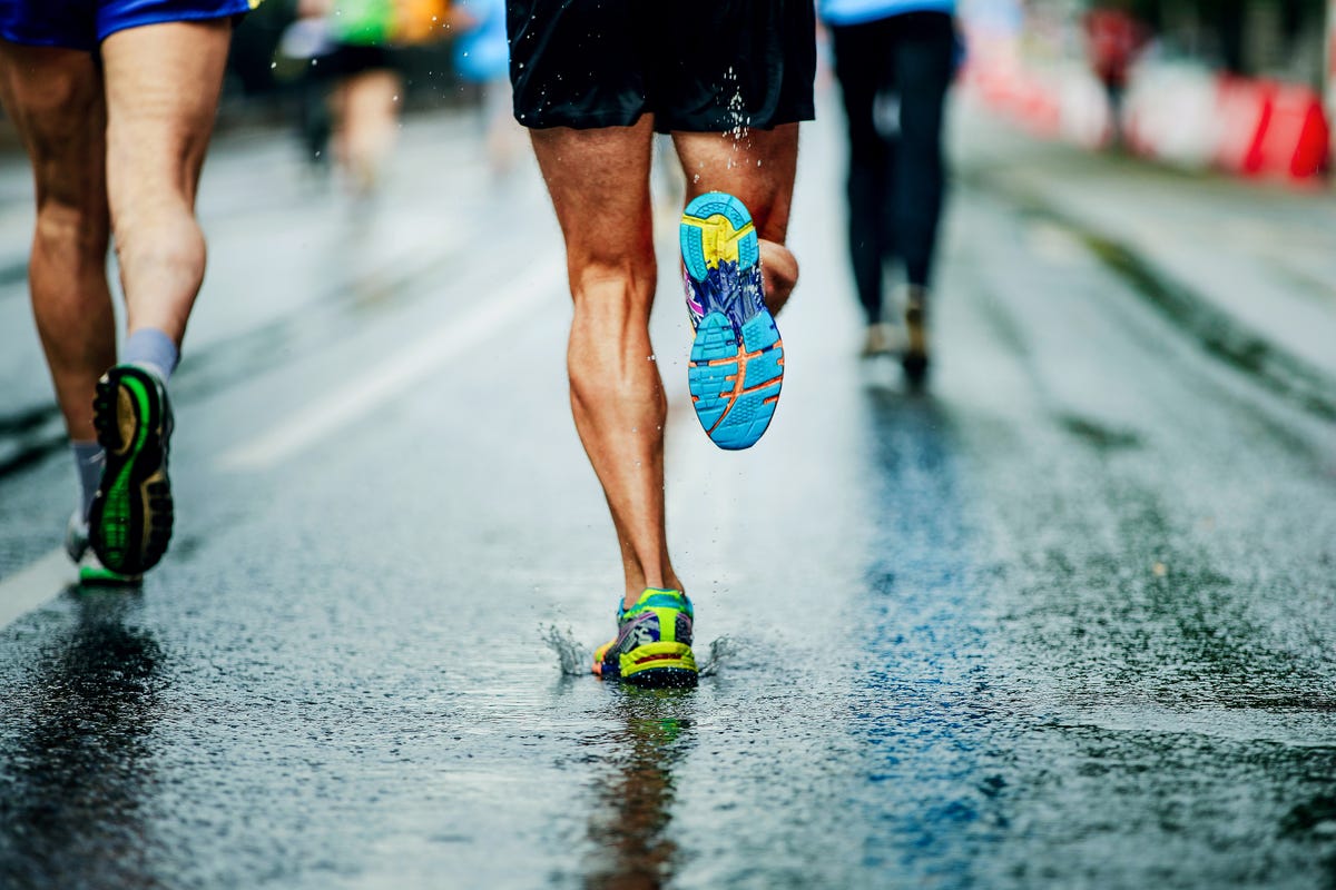 man loopt in de regen met hardloopschoenen