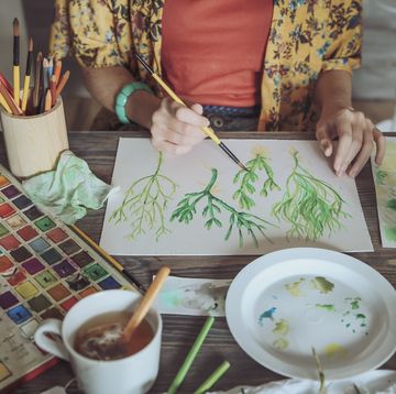 woman doing watercolour painting on wooden table