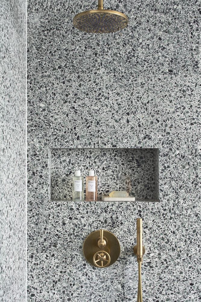 Terrazzo lined shower with brass fixtures