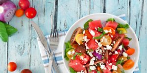 watermelon and tomato salad with feta, overhead on blue wood